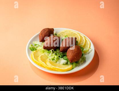 Kibbeh de style syrien servi sur un fond orange – apéritif arabe traditionnel Banque D'Images