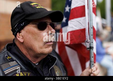 Portland, États-Unis. 26 mai 2025. Un membre des Patriot Guard Riders tient un drapeau. Le cimetière national de Willamette a célébré sa 75e célébration annuelle du Memorial Day à Portland, Oregon, le 26 mai 2025. (Photo de John Rudoff/Sipa USA) crédit : Sipa USA/Alamy Live News Banque D'Images