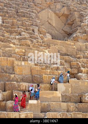 Visiteurs grimpant sur la Grande Pyramide de Gizeh Banque D'Images