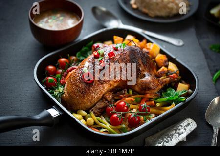 Canard entier farci et rôti servi avec des légumes de saison et des épices aromatiques Banque D'Images
