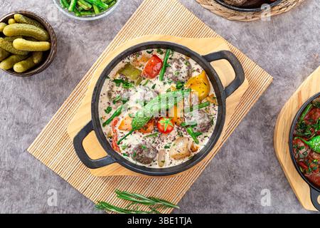 Kofta grillée avec tahini dans un plateau four, servi avec des légumes et des poivrons, nourriture arabe du moyen-Orient. Banque D'Images