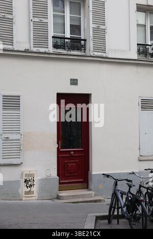Détail urbain : porte Rouge parisienne (N°66) avec vélos et Graffiti Element Banque D'Images