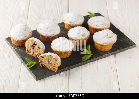 Stollen muffins pain aux fruits avec fruits secs et massepain enrobé de sucre glace en poudre gros plan sur la planche sur la table en bois. Horizontal Banque D'Images