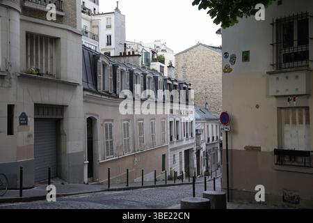 Rue pavée en pente avec architecture parisienne classique et toits Mansard Banque D'Images