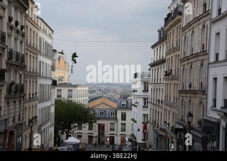 Vue atmosphérique sur la rue parisienne en pente avec des bâtiments haussmanniens et un paysage urbain Banque D'Images