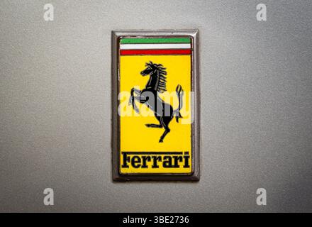 Emblème Ferrari classique affiché sur une surface argentée métallique, mettant en vedette le cheval emblématique qui se propage Banque D'Images