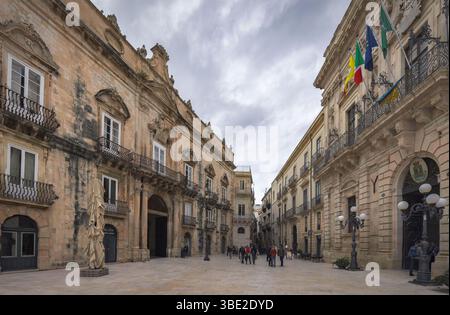 En se promenant dans Ortigia, les visiteurs admirent les bâtiments baroques complexes et un ciel dramatique, rehaussant l'ambiance, Sicile, Italie Banque D'Images
