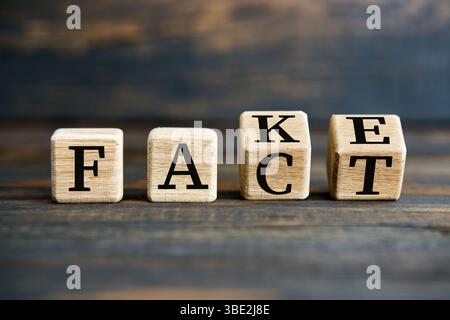 Retournement des blocs de cube en bois avec FAUX au texte DE FAIT sur fond en bois. Concept de manipulation Banque D'Images