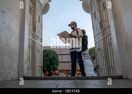 Voyageur asiatique en solo explorant la Thaïlande avec une carte en main - concept d'indépendance, d'aventure et de découverte de l'Asie du Sud-est Banque D'Images