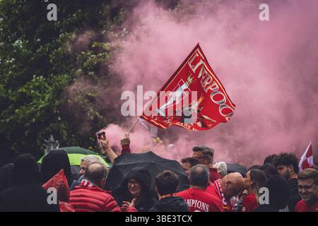 Des foules de fans de Liverpool avec des bombes fumigènes rouges et des drapeaux sur Queens Drive attendant de saluer le bus du Liverpool FC pendant le défilé de la premier League. Banque D'Images