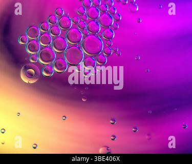 Bulles d'huile flottant sur l'eau avec un fond astract coloré Banque D'Images
