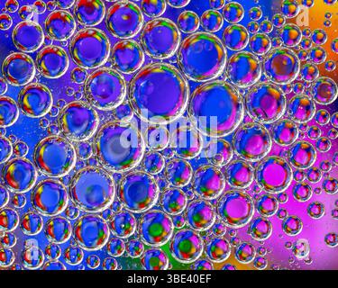 Bulles d'huile flottant sur l'eau avec un fond astract coloré Banque D'Images