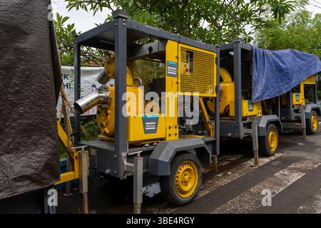 Bali, Indonésie - 28 décembre 2024 : trois camions jaunes et gris avec une bâche bleue sur le dessus. Les camions sont stationnés les uns à côté des autres Banque D'Images