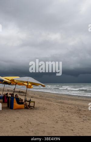 Bali, Indonésie-Dec28,2024 : scène de plage avec chaises de plage colorées et parasols. Les chaises sont disposées en rangée et il y a plusieurs tables dans le Banque D'Images