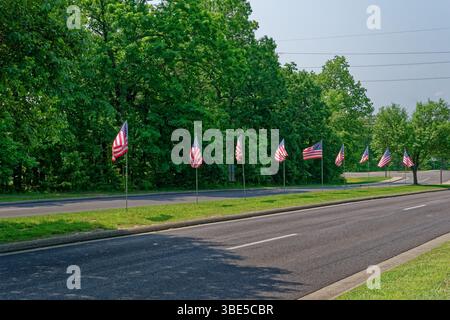 Rangée de plusieurs drapeaux américains pleine grandeur le long de la route dans le méridien pour les vacances du jour du souvenir sur une journée ensoleillée au printemps Banque D'Images