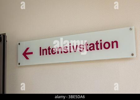 Deutschland 25. Avril 2025 : Im Bild : Ein schlichtes, aber klares Schild mit der Aufschrift Intensivstation und einem nach links zeigenden Pfeil ist an einer hellen, strukturierten Wand in einem Krankenhaus oder einer medizinischen Einrichtung angebracht. Der Schriftzug ist in einer gut lesbaren, dunklen Farbe gehalten, die sich deutlich vom hellen Hintergrund abhebt. DAS Bild konzentriert sich auf die wichtige Orientierungshilfe im Krankenhausumfeld. Dieses Foto eignet sich hervorragend für Beiträge über das Gesundheitswesen, Krankenhäuser, Kliniken, Intensivpflege, medizinische Notfälle, Pati Banque D'Images