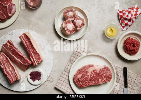 Un assortiment de viandes fraîches disposées sur des assiettes, présentant différentes coupes comme le steak, la queue de bœuf et le bœuf haché. Parfait pour illustrer un q de boucher Banque D'Images