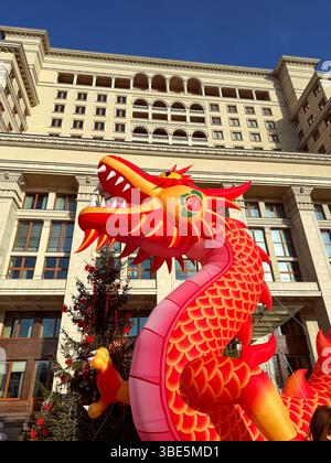 Des décorations vibrantes du nouvel an chinois ornent les rues de la ville, avec un grand dragon coloré sous un ciel bleu clair, apportant une joie festive Banque D'Images