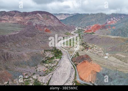 Une vue aérienne époustouflante capture les teintes vibrantes des montagnes entourant Purmamarca, un charmant village de Jujuy, en Argentine, mettant en valeur la nature Banque D'Images