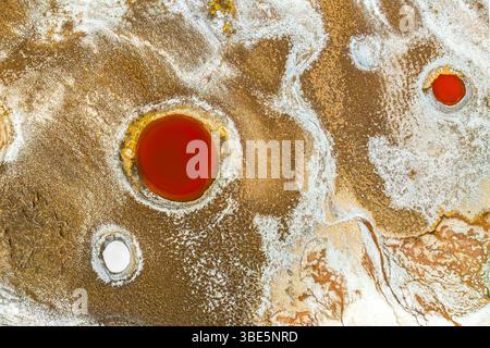 Vue de dessus, cette image capturée par drone montre les étonnantes piscines minérales de Salar de Antofalla à Catamarca, en Argentine. Orange vif et blanc minéral dép Banque D'Images