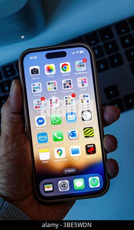 Gros plan de la main tenant l'écran d'accueil Apple iphone 14 Pro montrant les icônes des applications de messagerie de médias sociaux Messenger, WhatsApp, BBC, alexa, Outlook, google Banque D'Images