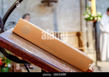 Un lectionnaire fermé, le livre liturgique utilisé pour les lectures scripturales pendant la messe catholique, reposant sur un pupitre à l'intérieur d'une église traditionnelle. Un sacré Banque D'Images
