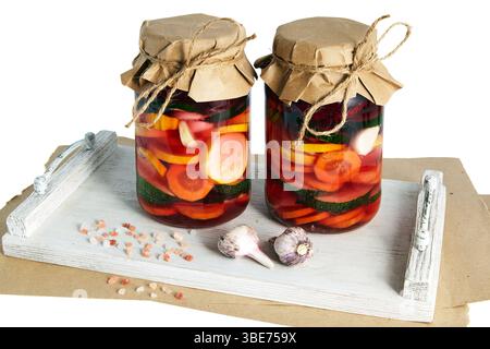 deux bocaux en verre avec divers légumes fermentés sur plateau en bois blanc Banque D'Images