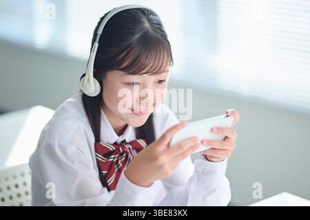 Des filles du secondaire suivent des cours sur smartphones Banque D'Images