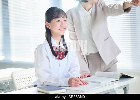 Fille du collège enseignant à l'école CRAM professeur comment étudier Banque D'Images