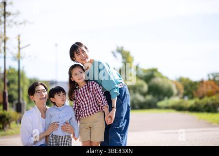 Famille de quatre personnes regardant loin dans le parc Banque D'Images