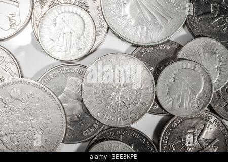 Diverses pièces de monnaie polonaises reposent sur une surface réfléchissante, présentant des motifs complexes et des symboles historiques. Banque D'Images