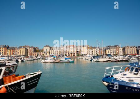 Dieppe, Normandie, France - 29 avril 2025. Vue sur le port avec des bâtiments colorés, pêche amarrée et bateaux de plaisance sous un ciel bleu clair. Banque D'Images