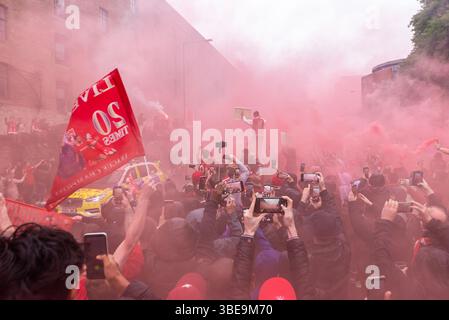 Défilé de la victoire des champions de Liverpool Football Club premier League dans la ville de Liverpool, au Royaume-Uni. Sécurité des voitures de police devant la cavalcade dans la fumée Banque D'Images