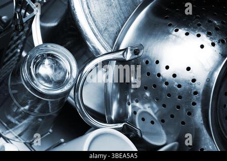 Ustensiles de cuisine en métal dans l'évier. Vaisselle lavée après cuisson. Pots et verrerie en acier inoxydable. Scène de nettoyage domestique. Détail lave-vaisselle. Banque D'Images