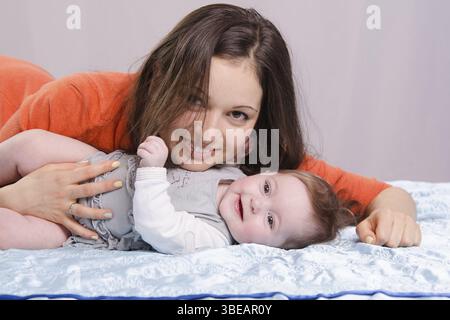 Mère et fille de six mois un plaisir de s'allonger sur le divan Banque D'Images