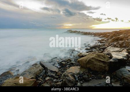 Un linceul de mer déchaînée sur une rive rocheuse Banque D'Images