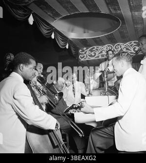 Portrait de (G-d) Junior Raglin, Lawrence Brown, Johnny Hodges, Duke Ellington, Ray Nance, Sonny Greer, Fred Guy, et Harry Carney, Aquarium, New York, N.Y., CA. Nov. 1946 Duke Ellington (assis) jouant avec Django Reinhardt à l'Aquarium de New York en novembre 1946. Edward Kennedy 'Duke' Ellington (29 avril 1899 - 24 mai 1974) est un pianiste de jazz américain, compositeur et chef de son orchestre de jazz éponyme de 1924 jusqu'au reste de sa vie. Ellington a écrit ou collaboré à plus d'un millier de compositions ; son vaste corpus de travail est le plus grand jazz personnel enregistré Banque D'Images