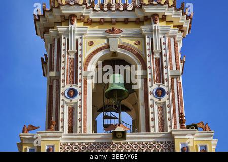 Vue détaillée d'une tour d'église décorée baroque avec cloche visible sous un ciel bleu, semaine Sainte, Baie de Panormitis, Monastère Panormitis, Symi, Dodeca Banque D'Images