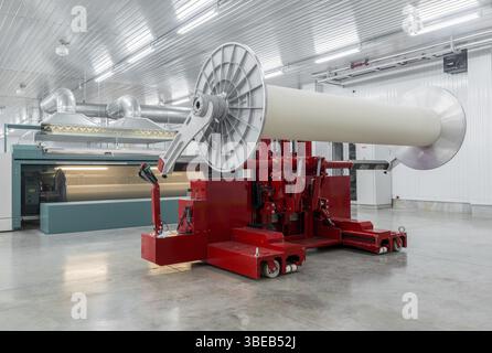 La machine hydraulique de levage soulève de grosses bobines. usine textile et filature Banque D'Images