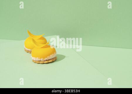 Un plateau de cupcakes jaunes fraîchement cuits avec délicieux glaçage blanc fouetté sur le dessus et fond vert Banque D'Images