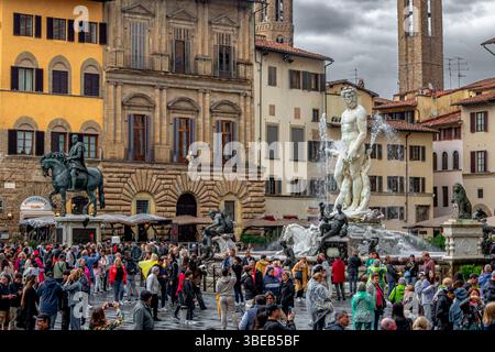 Foules de gens regardant la fontaine de Neptune sous de fortes pluies sur la Piazza della Signoria à Florence, Italie Banque D'Images