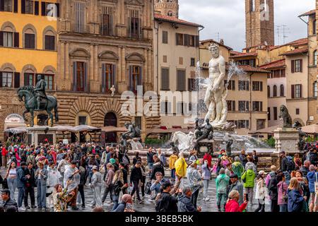 Foules de gens regardant la fontaine de Neptune sous de fortes pluies sur la Piazza della Signoria à Florence, Italie Banque D'Images