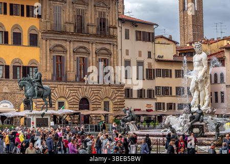 Foules de gens regardant la fontaine de Neptune sous de fortes pluies sur la Piazza della Signoria à Florence, Italie Banque D'Images