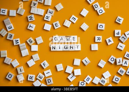 Jeu de société de tuiles de lettre sur fond orange avec des mots Game Night Banque D'Images