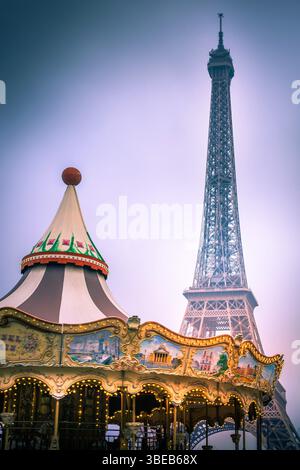 Un carrousel vintage tourne joyeusement dans un parc, avec la Tour Eiffel majestueusement en arrière-plan.Paris. France Banque D'Images