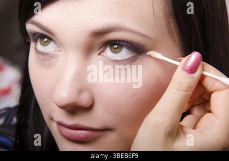 Maquilleur traite le maquillage sur le visage du modèle. Elle peint les ombres du modèle des paupières supérieures Banque D'Images