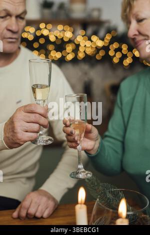 Heureux couple âgé célébrant l'anniversaire de mariage. 60s heureuse retraite. Saint-Valentin pour les aînés. Date champagne. Banque D'Images