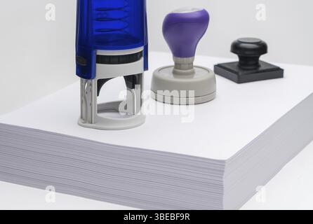 Groupe de tampon en caoutchouc différent sur un paquet de feuilles de papier blanc Banque D'Images