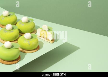 Un plateau de beignets verts assortis est posé sur une table en bois Banque D'Images