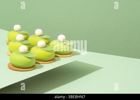 Un plateau de beignets verts assortis est posé sur une table en bois Banque D'Images